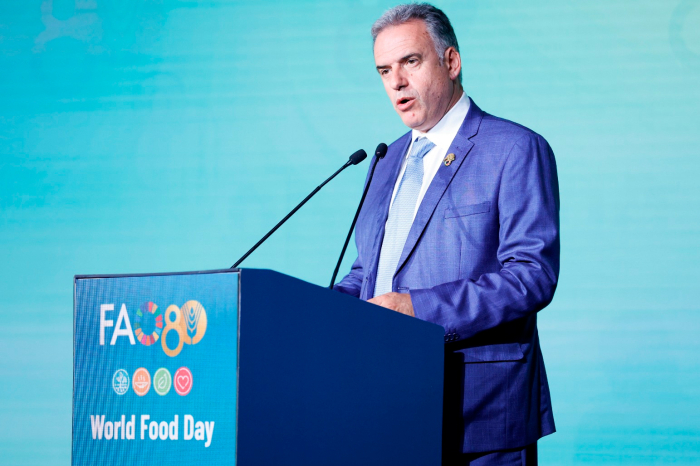 Presidente Yamandú Orsi, de pie, habla frente a un estrado que tiene un logotipo de 80° aniversario de la FAO
