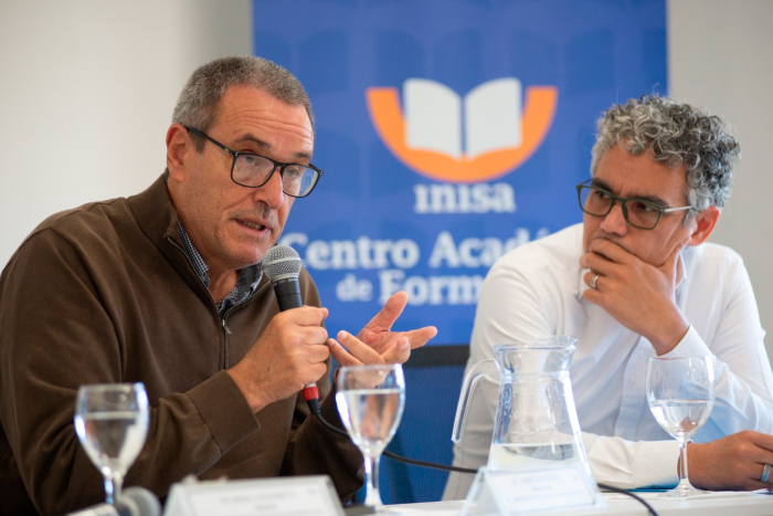 Presidente de Insa, Jaime Saavedra, habla con micrófono en mano. A su lado, lo observa atentamente el representante de Unicef Uruguay, Francisco Benavides
