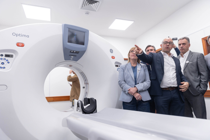 Presidente Yamandú Orsi, de pie, observa el tomógrafo del hospital de Colonia. A su lado, el presidente de ASSE le da explicaciones con el brazo extendido. La ministra de Salud, Cristina Lustemberg, observa con los brazos cruzados