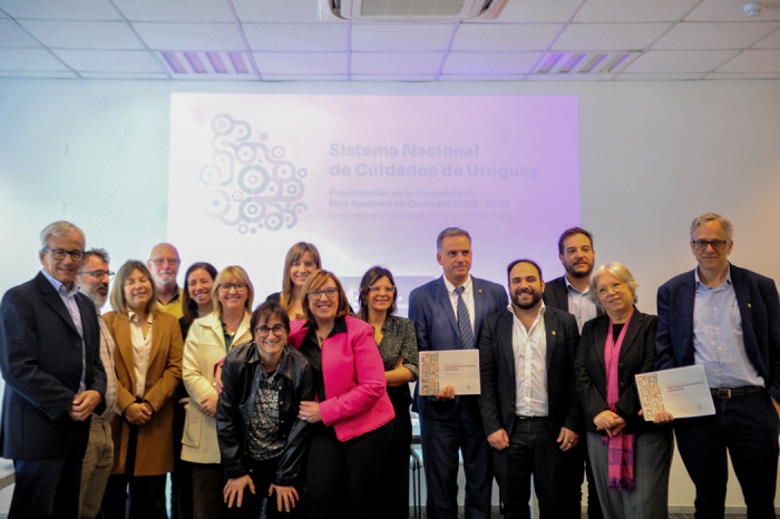 El presidente de la República, Yamandú Orsi, sostiene el documento impreso del plan nacional de Cuidados. Junto a él, el resto de los integrantes de la Junta Nacional de Cuidados