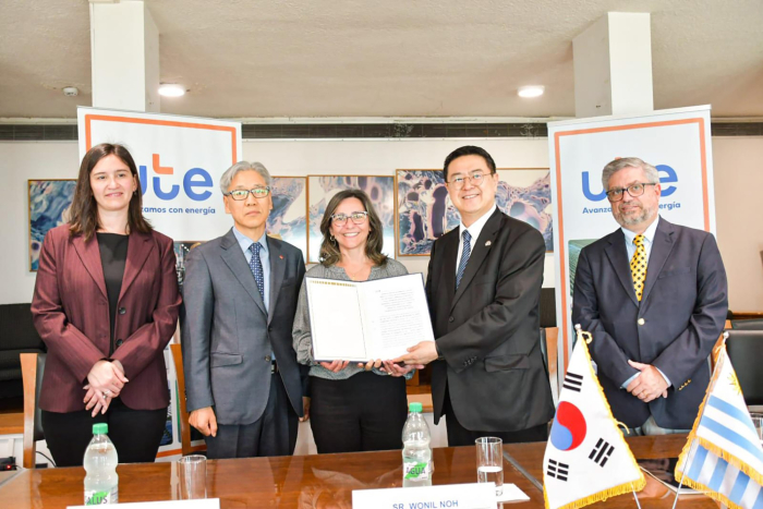 Presidenta de UTE, Andrea Cabrera, sostiene el contrato firmado con el consorcio coreano. A su lado, representantes del consorcio y directores de la empresa estatal