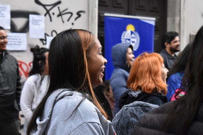 Personas migrantes disfrutan de un espectáculo artístico al aire libre