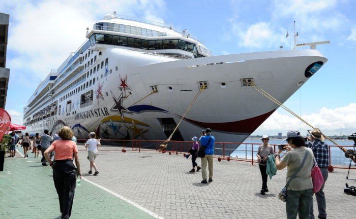 Turistas le toman fotografías a un crucero en el puerto de Montevideo