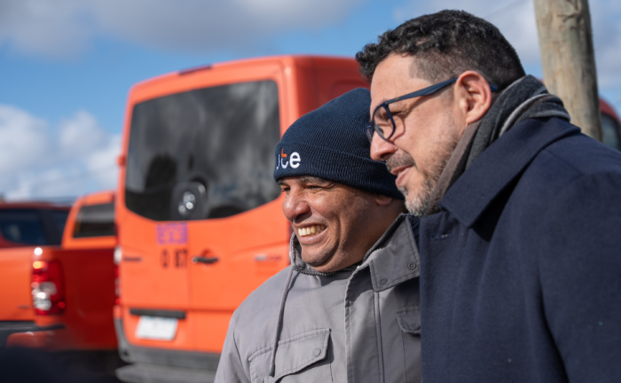 Más de 400 hogares de Nuevo Comienzo accedieron a conexión eléctrica segura y red de agua potable Secretario de Presidencia, Alejandro Sánchez, se toma una foto con un vecino del barrio Nuevo Comienzo. Detrás de ellos, dos vehículos de UTE