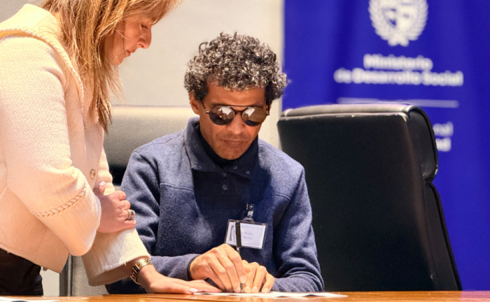 Desarrollo Social promueve convenios para fortalecer la atención y la inclusión de personas con discapacidad visual. Foto: Mides Persona con discapacidad visual firma un convenio en durante el congreso internacional Visionia 2026
