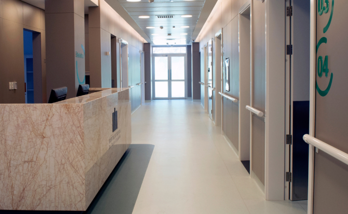 Pasillo del Hospital de Clínicas. A la izquierda, un mostrador con el logo del hospital. A la derecha, puertas de salas. 