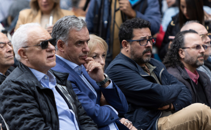 Presidente Yamandú Orsi observa el escenario, sentado en primera fila, con una mano en el mentón. A su lado, el secretario de Presidencia, Alejandro Sánchez, cruzado de brazos, y el canciller Mario Lubetkin, de lentes.