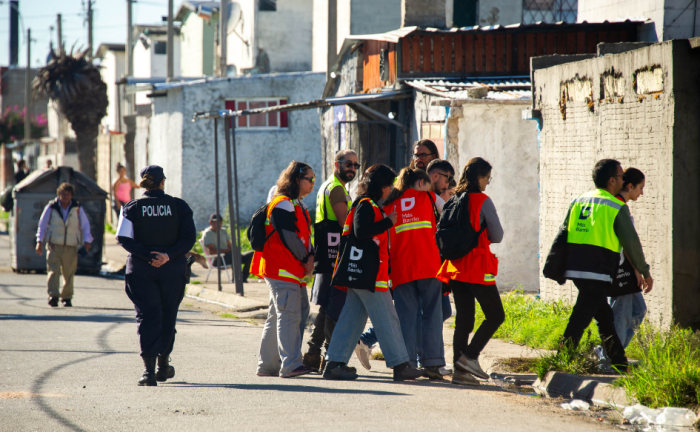 Cencistas identificados con chalecos caminan por una calle de Cerro Norte