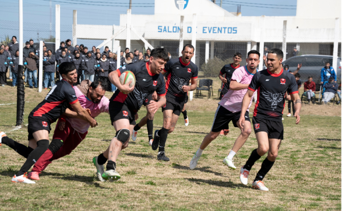 Personas privadas de libertad juegan al rugby en la cancha de la unidad n°4 del INR, durante la celebración del 10° aniversario del programa de rugby en cá