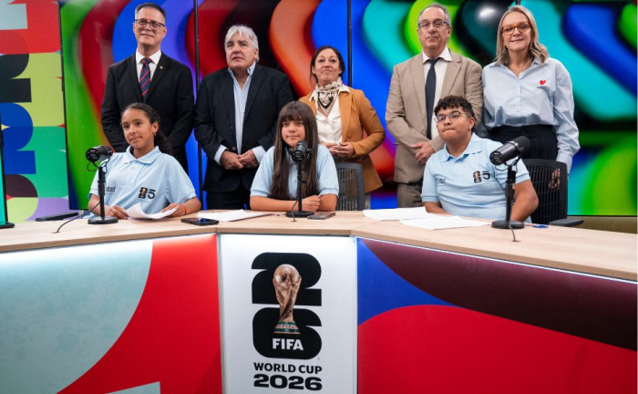Ministra de Industria, ministro de Educación, directora de Canal 5, presidente de Antel, y director de Dinatel, de pie, en el estudio principal de Canal 5 en el LATU. Frente a ellos, tres niños con camiseta celeste, sentados. Delante, el logo de la Copa Mundial de la FIFA 2026