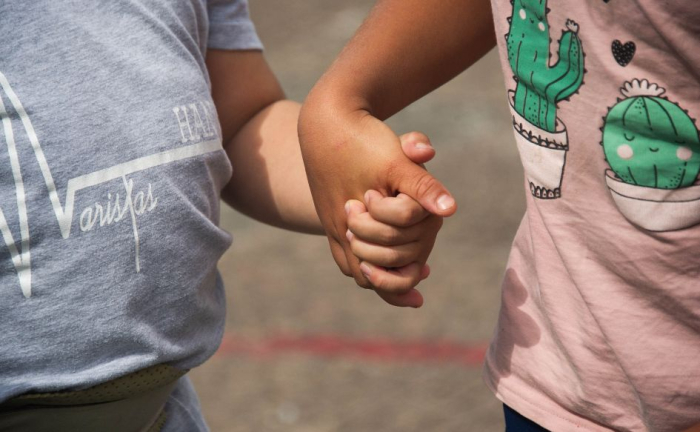 Dos niños de unos tres años se toman de la mano. Foto de archivo