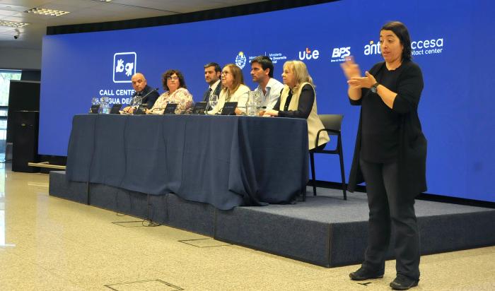 Autoridades de las instituciones participantes en la mesa principal y una intérprete de lengua de señas
