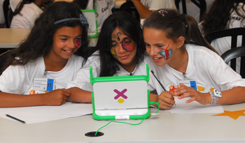 Niñas utilizan una computadora del Plan Ceibal