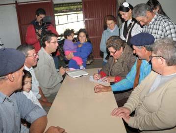 Colonos firmando entrega