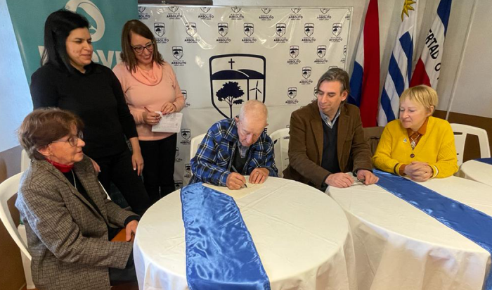 Vecino de Cerro Largo firma su escritura junto a autoridades departamentales y del Mevir