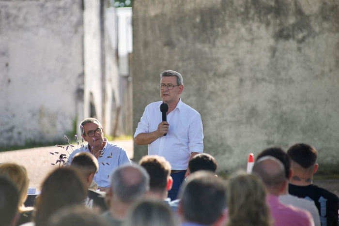 El prosecretario de Presidencia, Jorge Díaz, de pie, habla con micrófono en mano. Delante de él, decenas de jóvenes de Inisa. Al fondo, un galpón del predio del instituto
