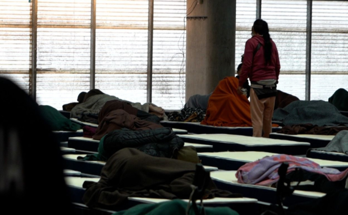 Alerta por frío extremo: 3.707 personas en situación de calle fueron asistidas el sábado 4 de julio Una persona de pie entre varias camas dispuestas en fila en el polideportivo de la Escuela Nacional de Policía