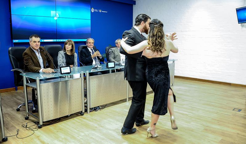 Mesa de autoridades del evento viendo a una pareja que baila tango