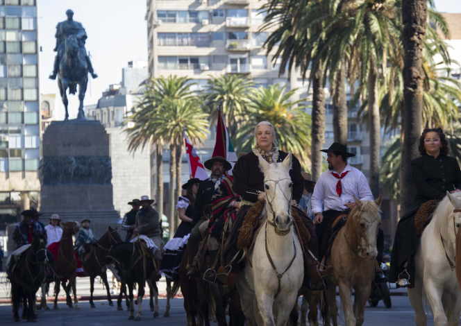 Grupo de jinetes desfilan por la avenida 18 de Julio