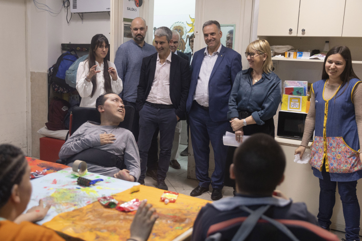 Presidente Yamandú Orsi parado, con las manos en los bolsillos, observa a adolescentes del Centro Horizonte, que trabaja