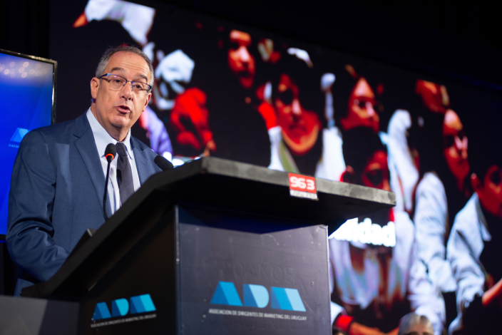 Ministro de Educación y Cultura, José Carlos Mahía, brinda un discurso de pie, detrás de un estrado. En el fondo, una pa