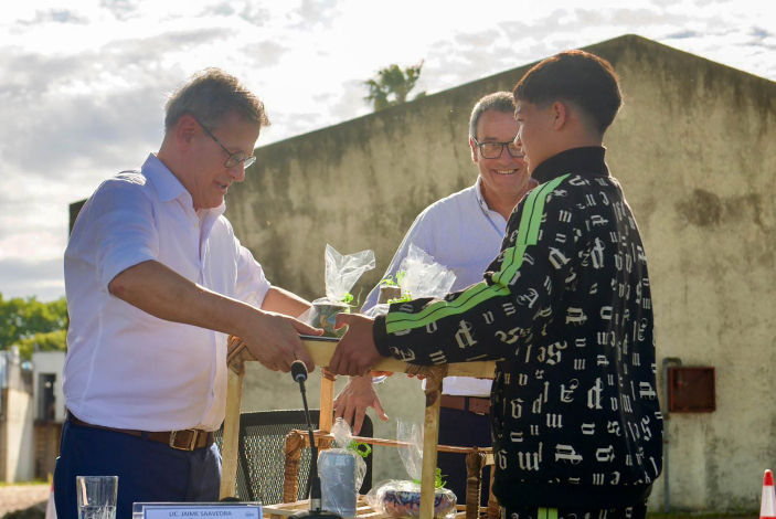 Joven del Inisa entrega obsequio a Jorge Díaz, acompañado por Jaime Saavedra
