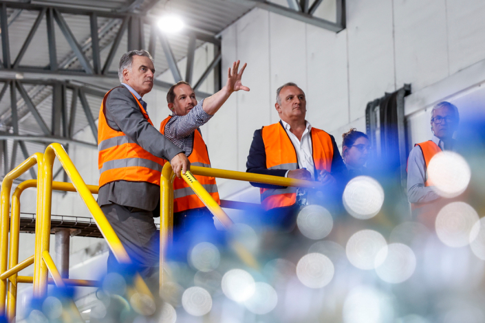 Presidente Yamandú Orsi, con chaleco anaranjado, observa la planta industrial de Salus. A su lado, un técnico señala el