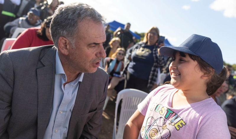 Presidente Orsi con niña en el barrio Nuevo Comienzo