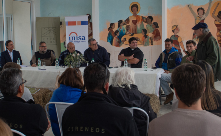 Personas observan a un hombre de unos 60 años, que habla mirando hacia donde están sentados el presidente de Inisa, Jaim