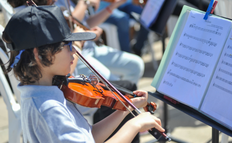 Niño de unos ocho años de edad toca el violín