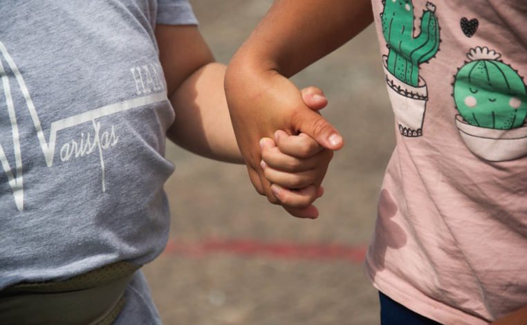 Dos niños de unos tres años se toman de la mano. Foto de archivo