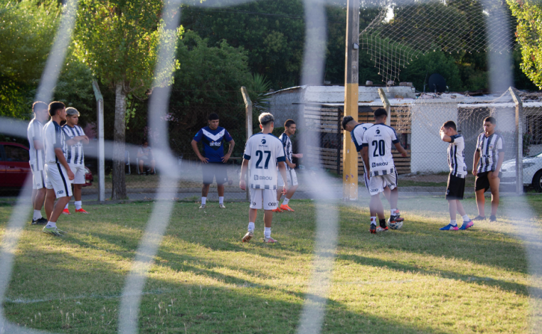 Niños de unos 13 años juegan con una pelota en una cancha de fútbol infantil