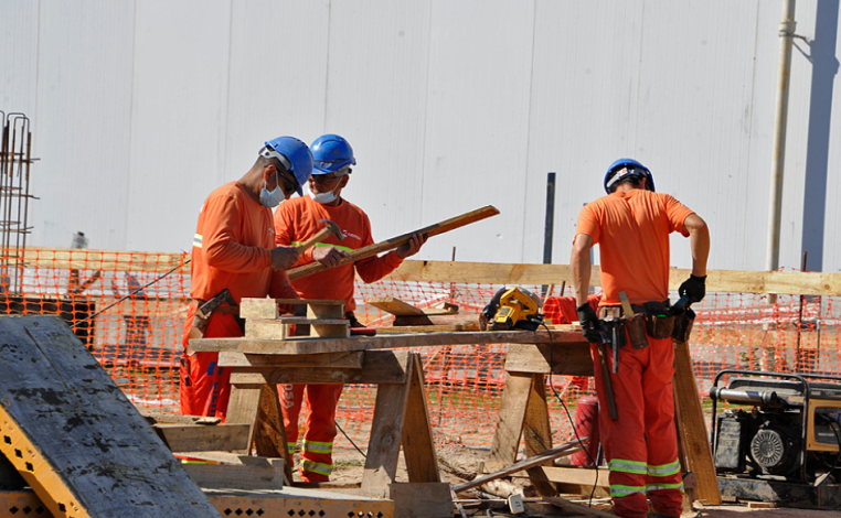Tres obreros de la construcción trabajan en una obra
