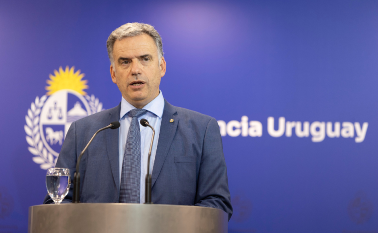 Presidente Yamandú Orsi habla detrás de un atril. Detrás, un back con el escudo nacional y la leyenda "Presidencia Urugu