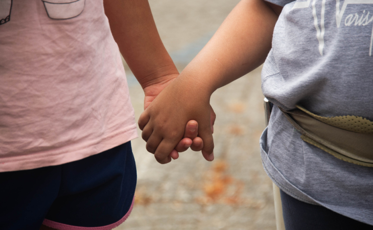 Un niño y una niña tomados de la mano