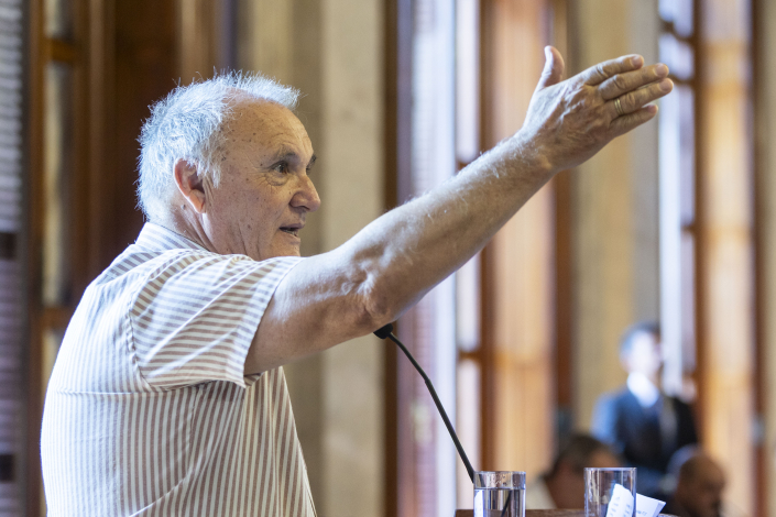 El impulsor del proyecto Cosechando Esperanzas, Richard Read, habla de pie, con el brazo derecho extendido hacia adelant