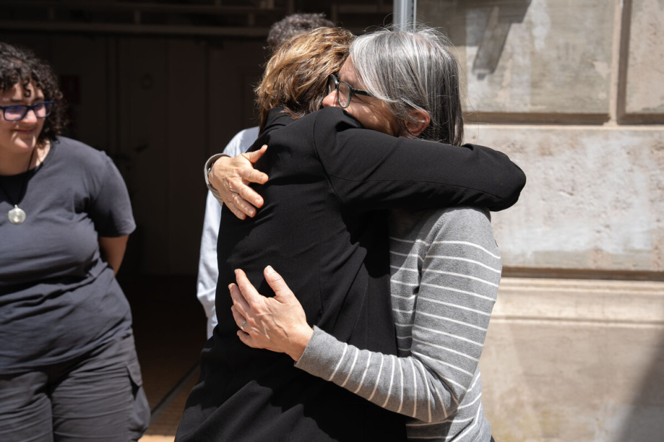 Mariana Mota e Iliana da Silva durante la transferencia de archivos a la INDDHH. Mariana Mota e Iliana da Silva se abrazan frente a un edificio.