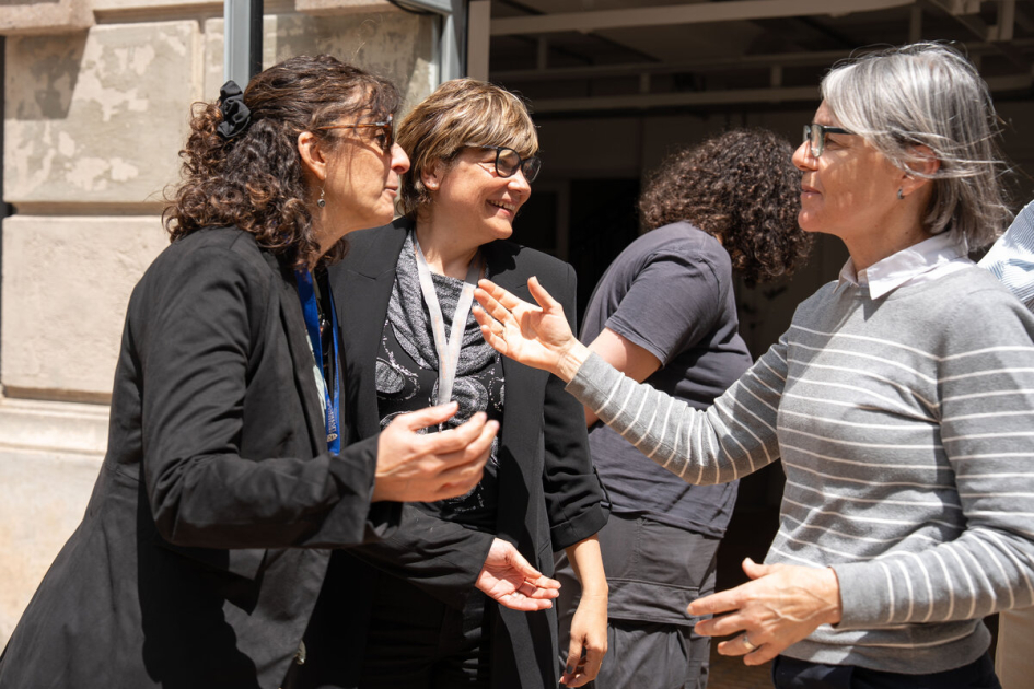 Mariana Risso, Mariana Mota e Iliana da Silva durante el traslado de archivos a la INDDHH. Mariana Risso, Mariana Mota e Iliana da Silva conversan frente a un edificio.