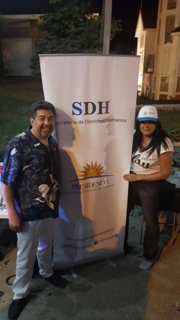 Representantes de la SDH - Nelson Villarreal y Perla Rodriguez junto a banner de la SDH