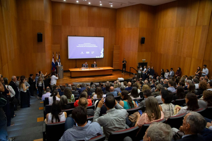 Audiencia en el auditorio sentada mientras hablan Orsi y Gonzalez