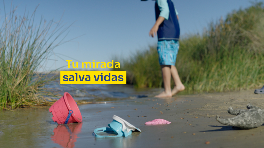 Un niño en la orilla de un río junto a sus juguetes