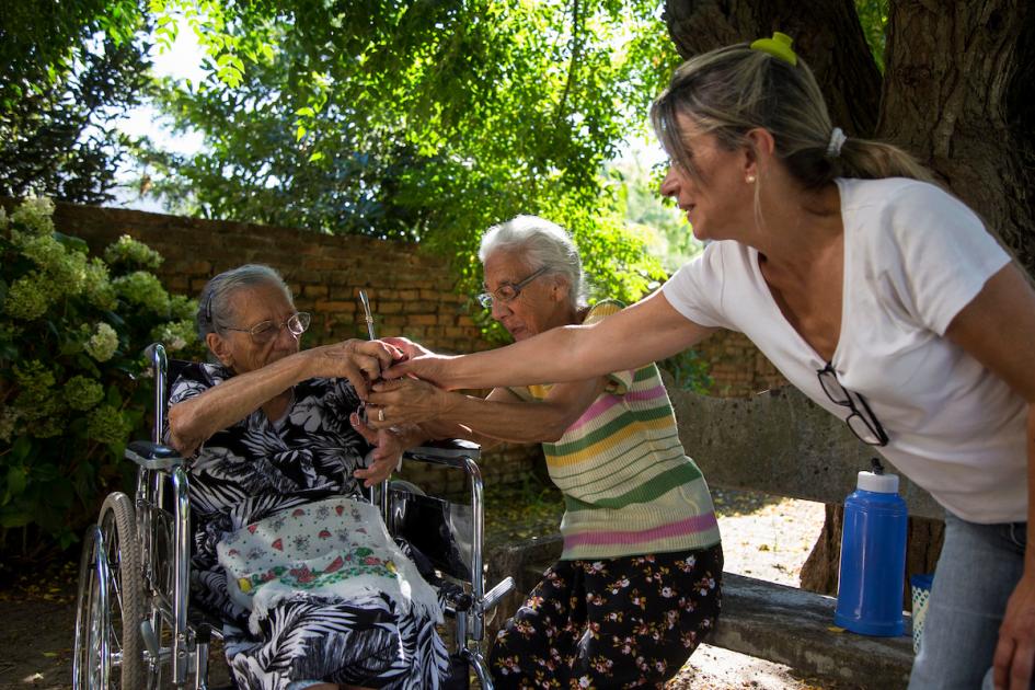 María y Luciana, de 95 y 80 años respectivamente, comparten un mate con Laura, la asistente personal de ambas