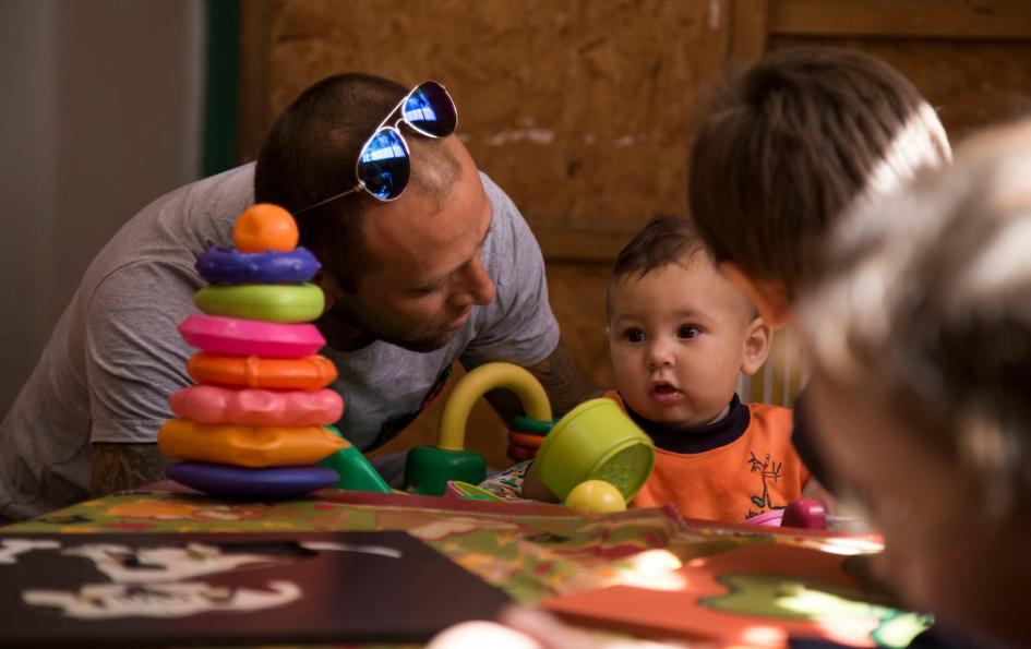 Justin, un niño de un año, junto a su padre en el jardín donde lo cuidan Justin, un niño de un año, junto a su padre en el jardín donde lo cuidan