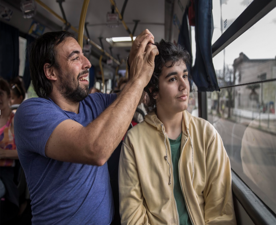 Florencia y Nacho, su asistente personal, viajando en un ómnibus