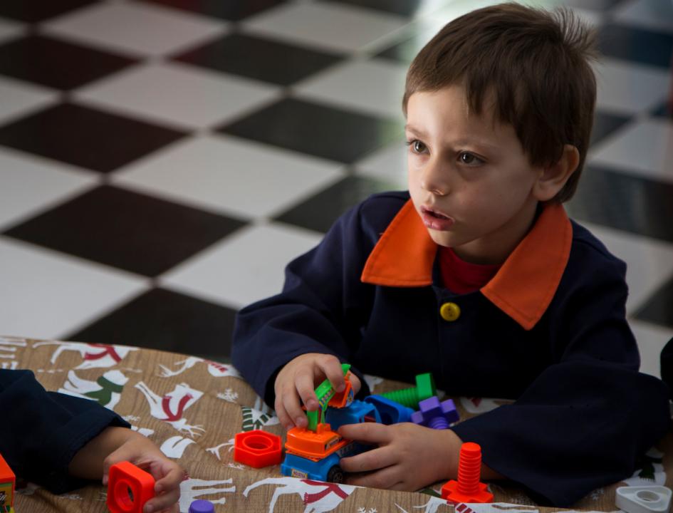 Niñp juega en un centro de educación y cuidados Niño juega en un centro de educación y cuidados