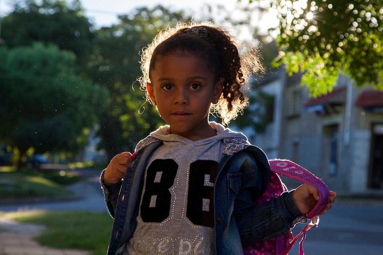 Niña acomoda su mochila antes de ir al centro de hijos de estudiantes Niña acomoda su mochila antes de ir al centro de hijos de estudiantes