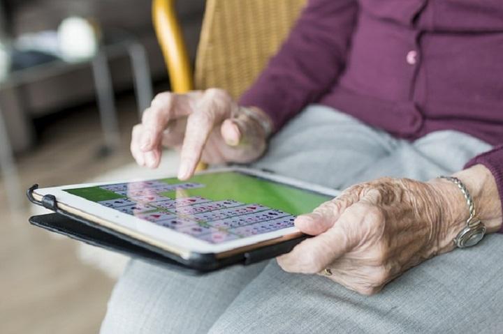 Manos de persona mayor jugando con su tablet Manos de persona mayor jugando con su tablet