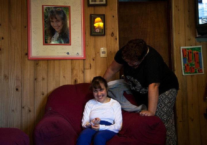 Rosanela, asistente personal, ayuda a sentarse a Nati, una adolescente en situación de dependencia Rosanela, asistente personal, ayuda a sentarse a Nati, una adolescente en situación de dependencia