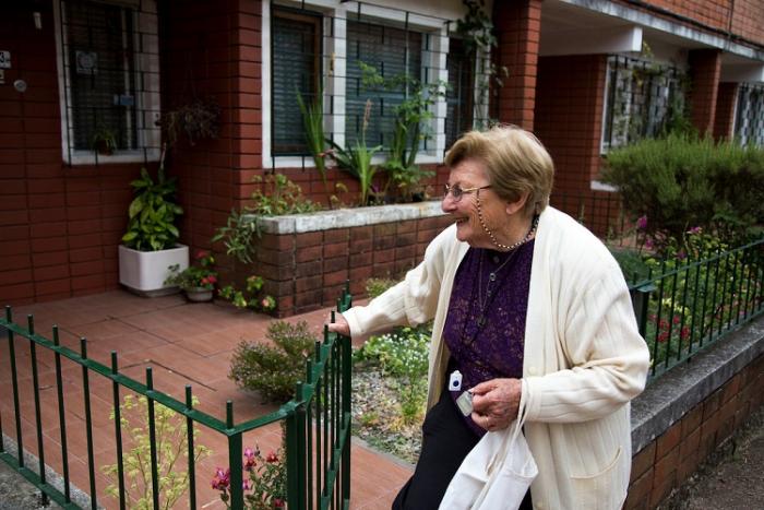 Angélica, usuaria de Teleasistencia en casa, entrando a su domicilio. Se ve moviendo el portón de su casa.