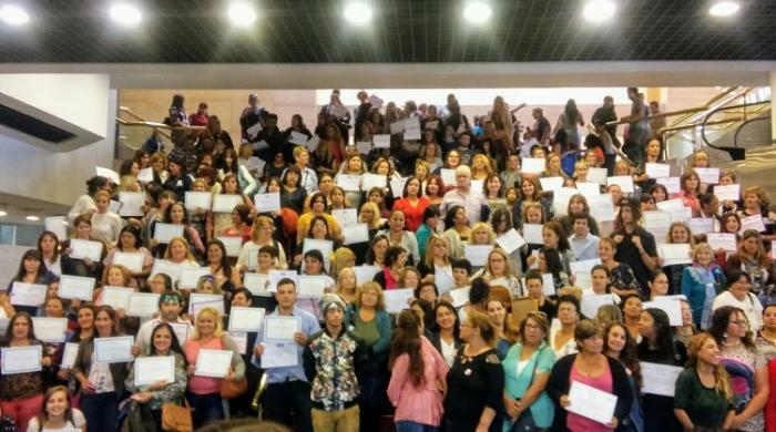 Egresadas muestran sus diplomas en la escalera del Auditorio Adela Reta 